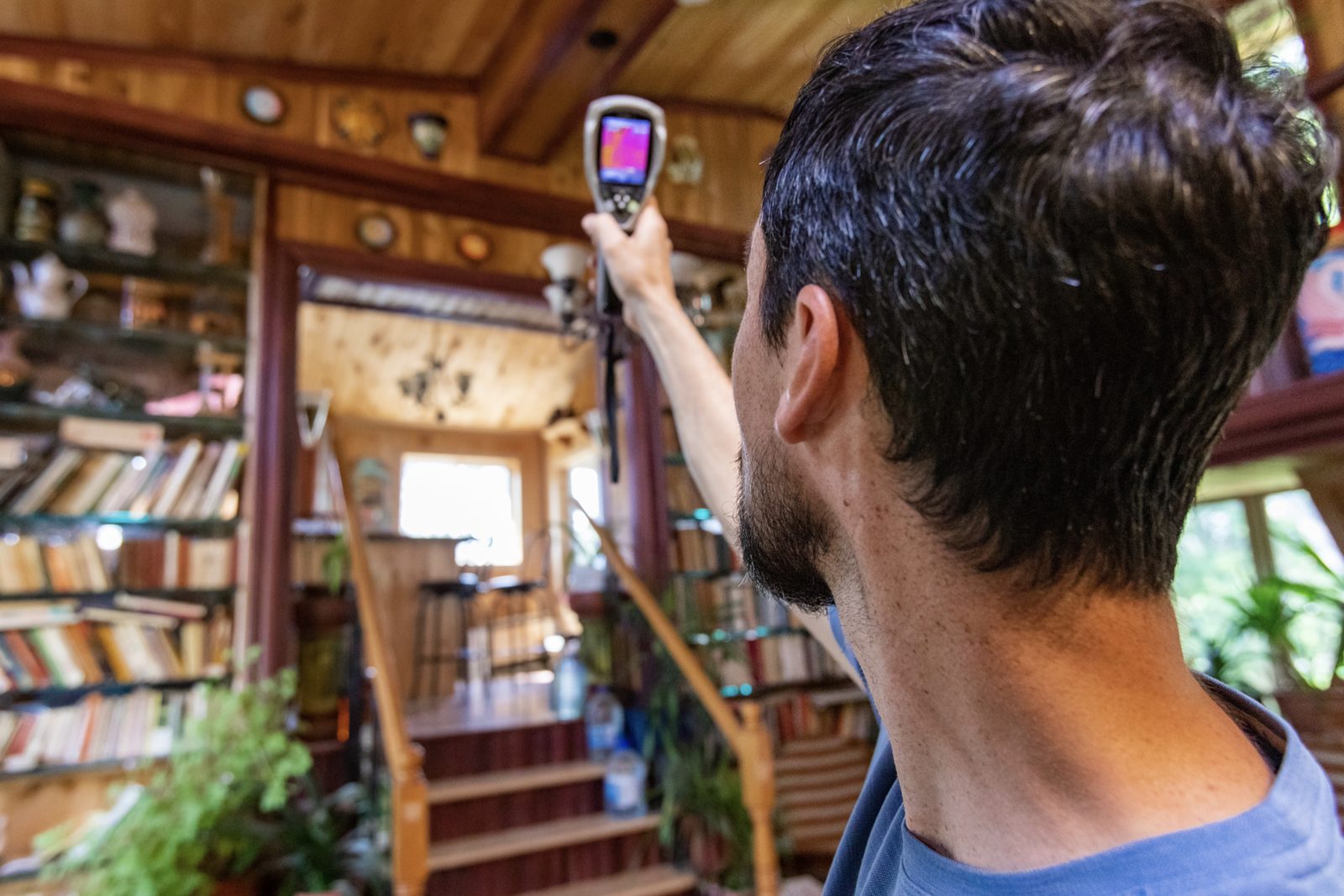 A home inspector scanning a home's interior with an infrared thermal imaging camera